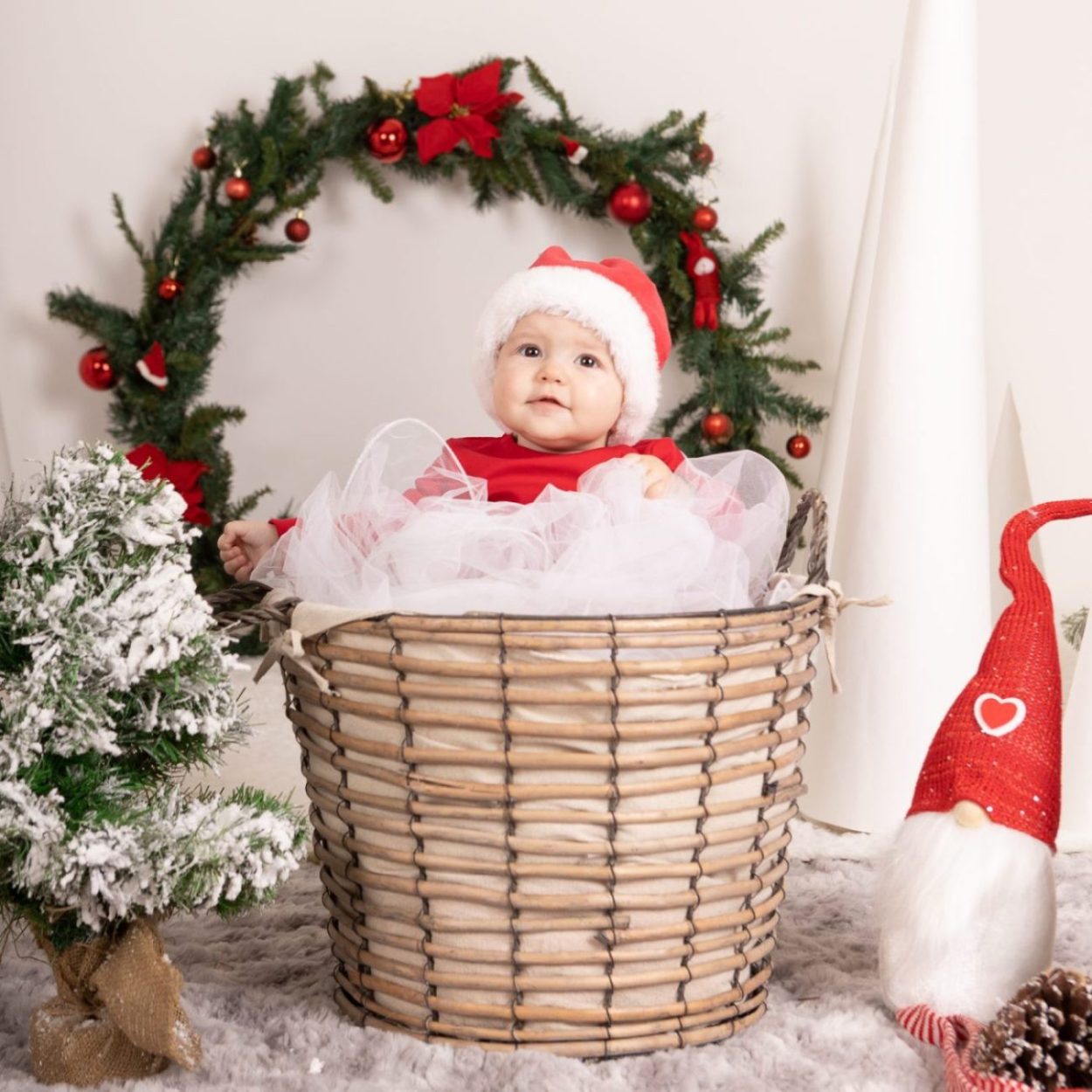 bambino servizio fotografico natalizio cesta di natale ghirlanda cappellino da babbo natale