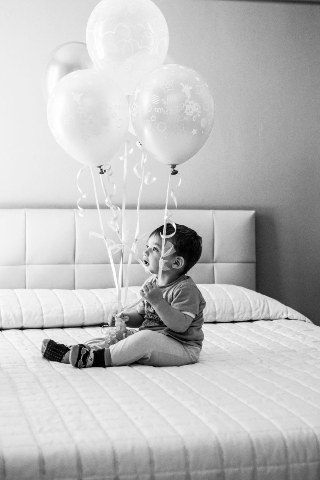 bambino palloncini fotografia in casa letto festa bianco e nero preparativi neonato famiglia cerimonia fotografo