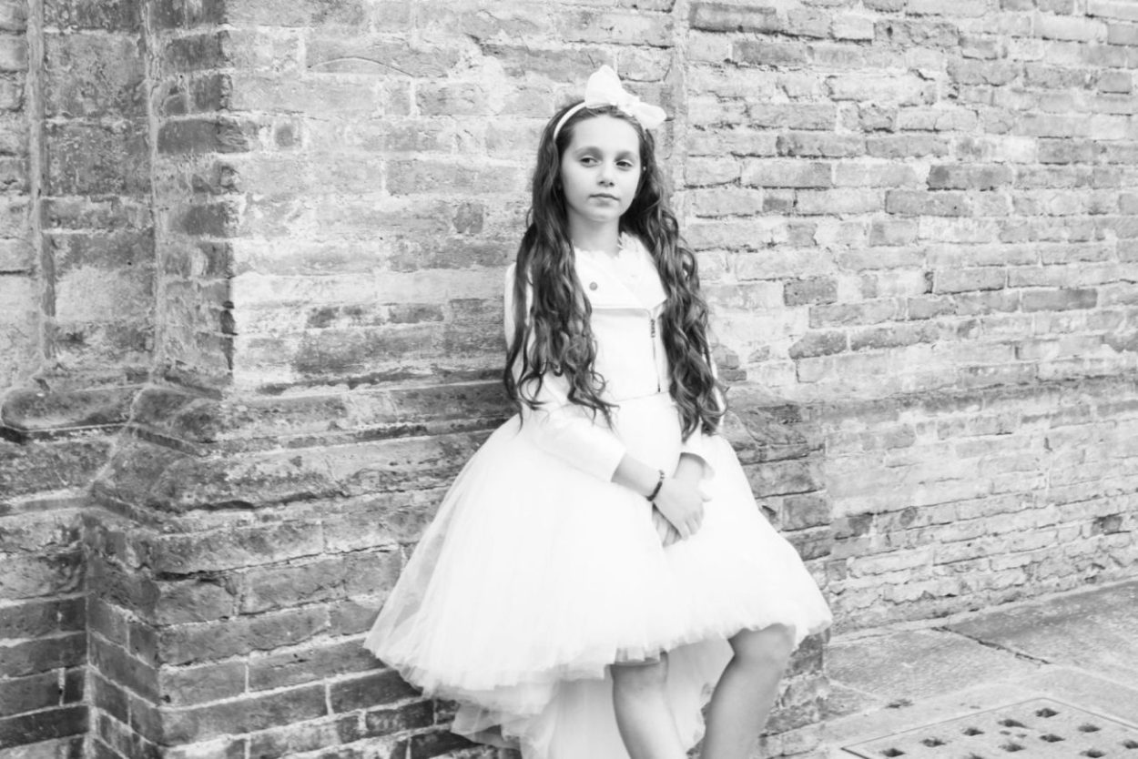 bambina comunione bianco e nero vestito bianco sorriso acconciatura boccoli fiocco cerchietto servizio fotografico sacramenti servizio fotografico fotografo