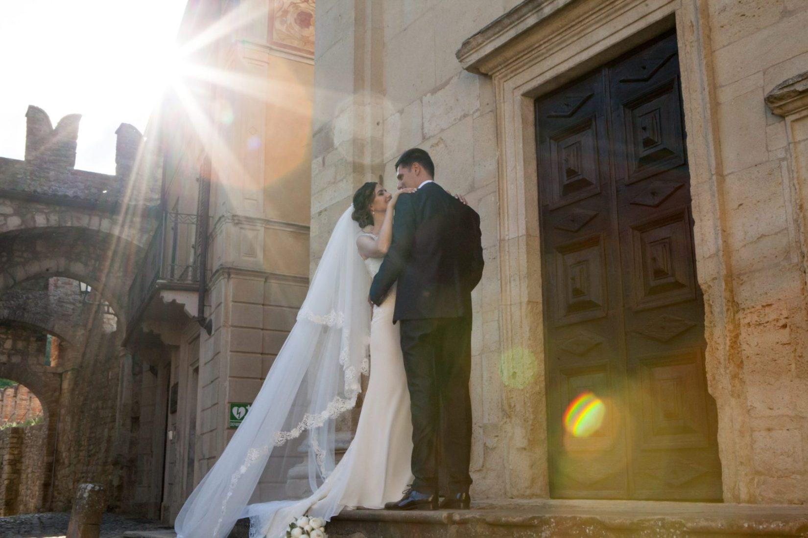 fotografia sposi fuori dalla chiesa appena sposati romantico con giochi di luce matrimonio cerimonie