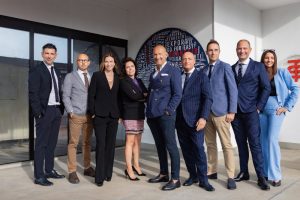 Gruppo dirigenziale fotografato davanti all'edificio aziendale