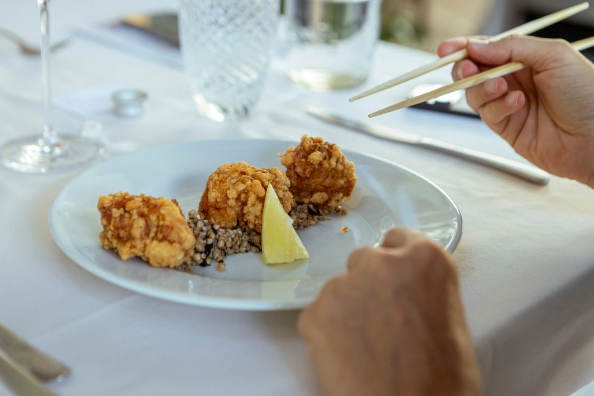 Piatto di bocconcini fritti degustato con le bacchette durante una cena