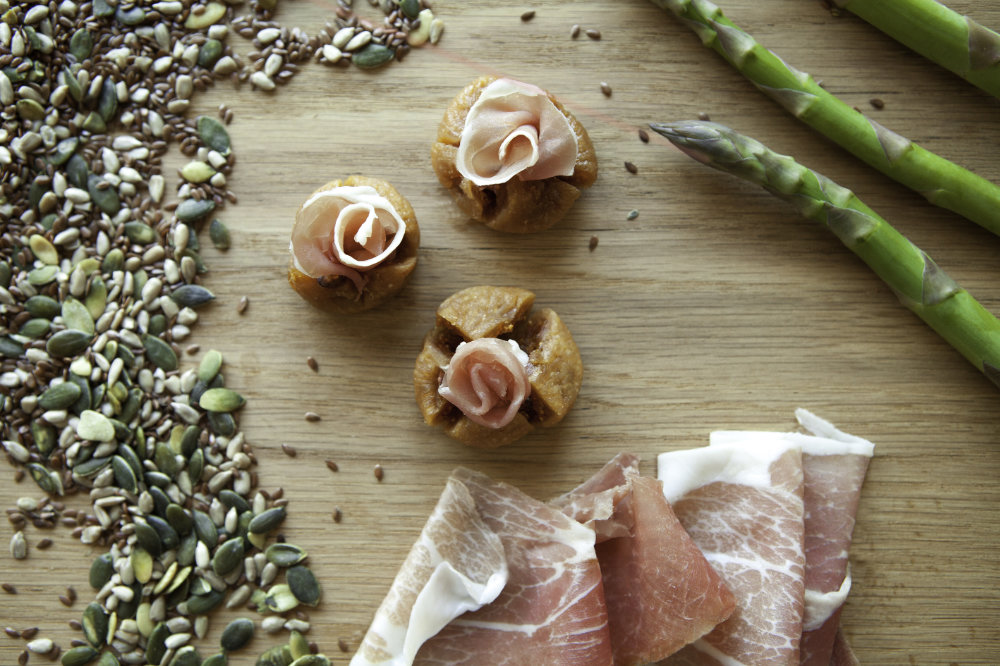Roselline di prosciutto crudo su tagliere in legno per un servizio fotografico food & wine